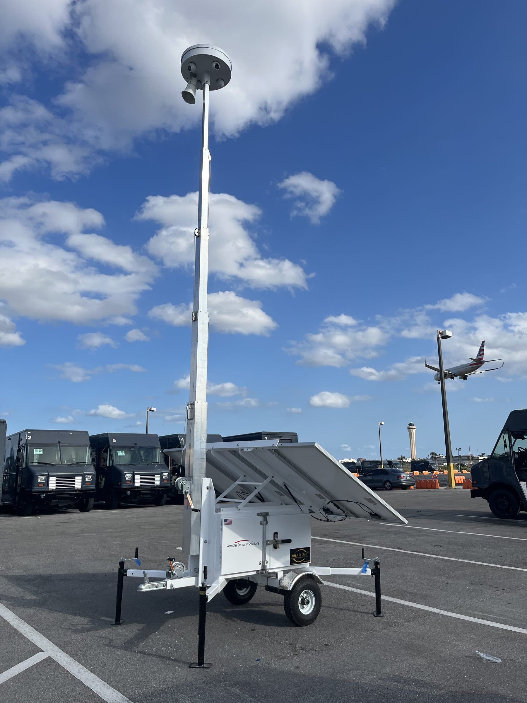 SolarCam360 surveillance unit monitoring an airport logistics lot as a plane lands