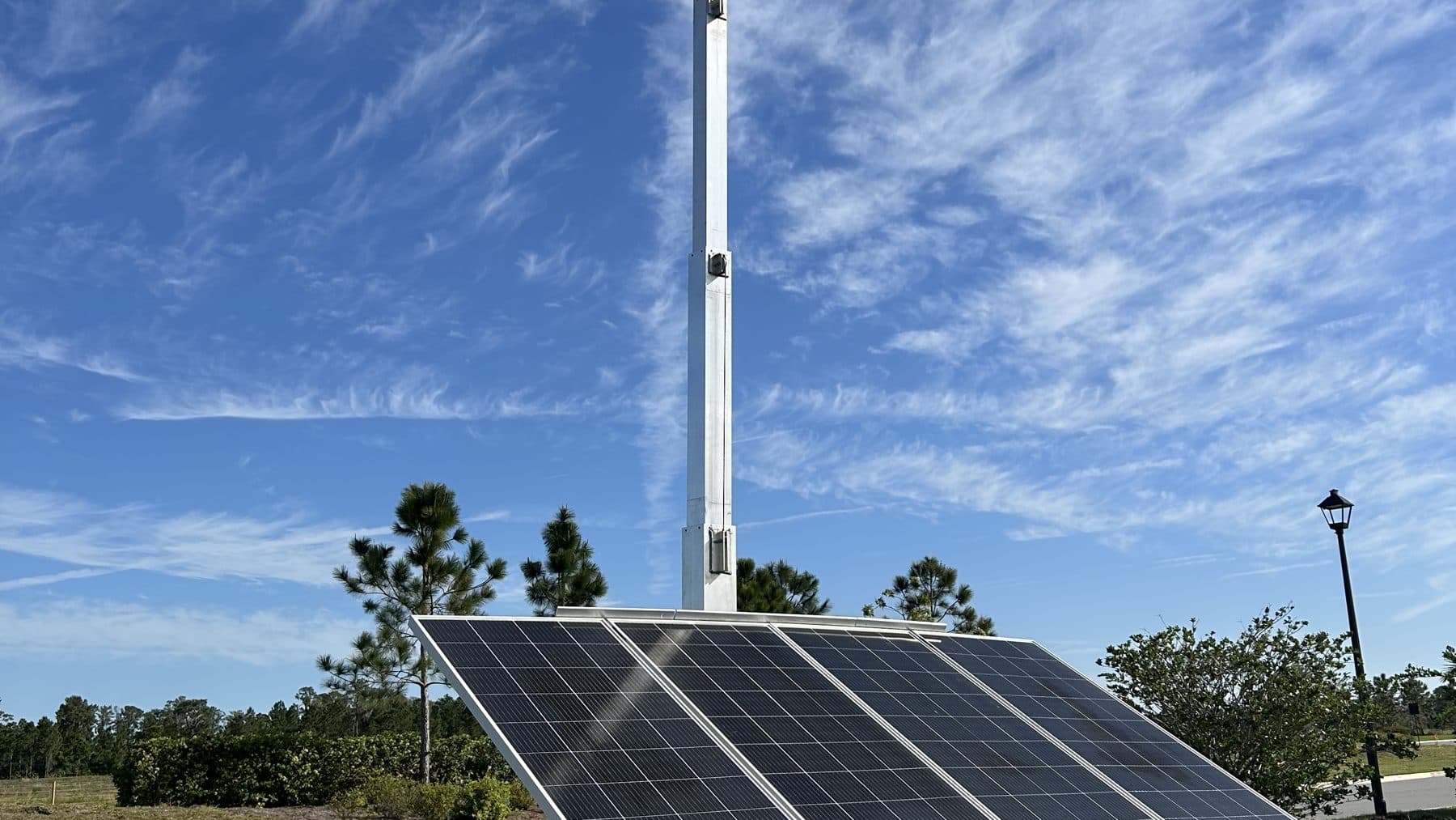 SolarCam360 solar panel array and camera mast under an open sky