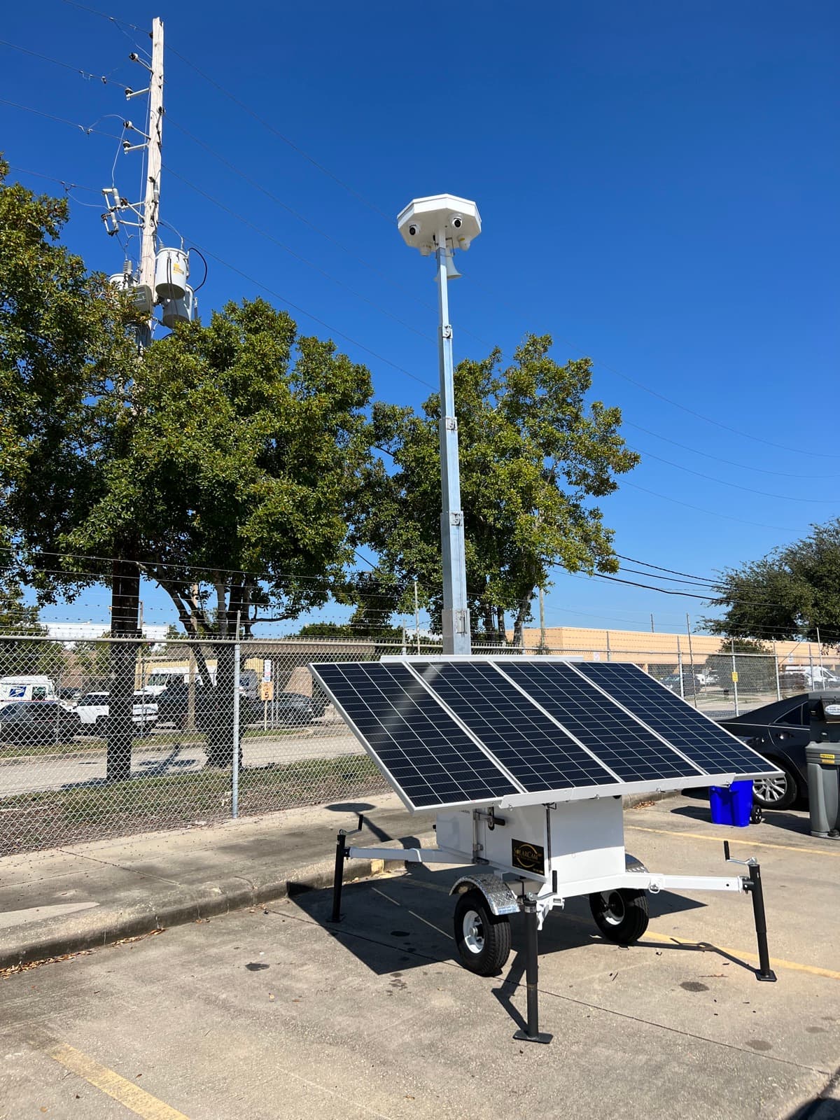 SolarCam360 G7 solar surveillance unit covering a fenced commercial lot