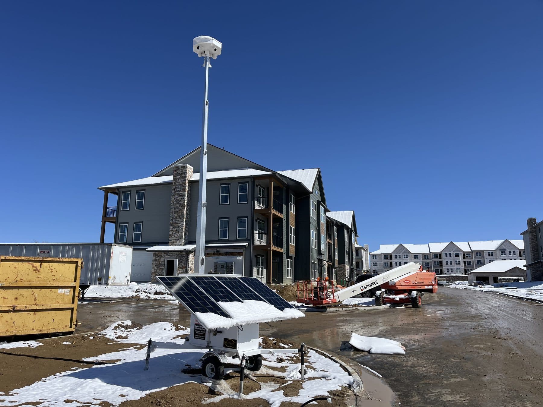 SolarCam360 unit monitoring a snowy apartment construction site